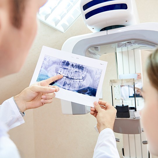 Dentist and patient looking at digital dental x-rays