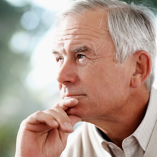 Older man contemplating dental crown restoration