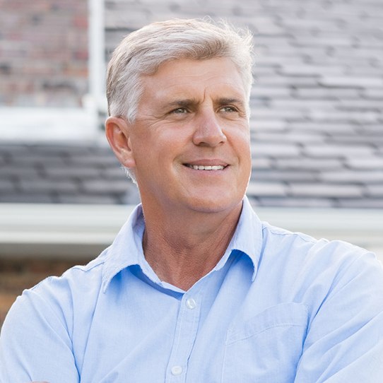 Man smiling after dental implant tooth replacement