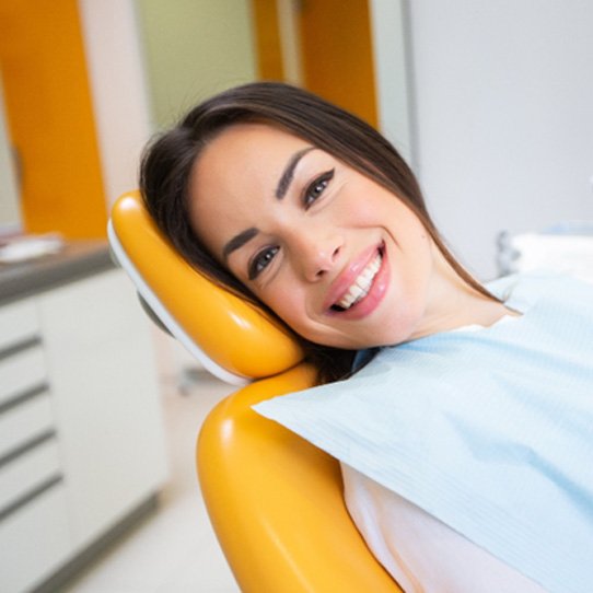 Woman smiling after receiving dental implants