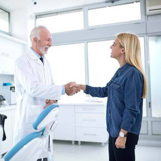 Emergency dentist shaking hands with a patient