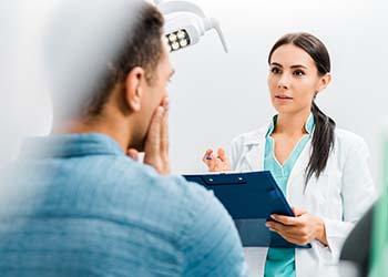 Dentist explaining cost of treating dental emergencies