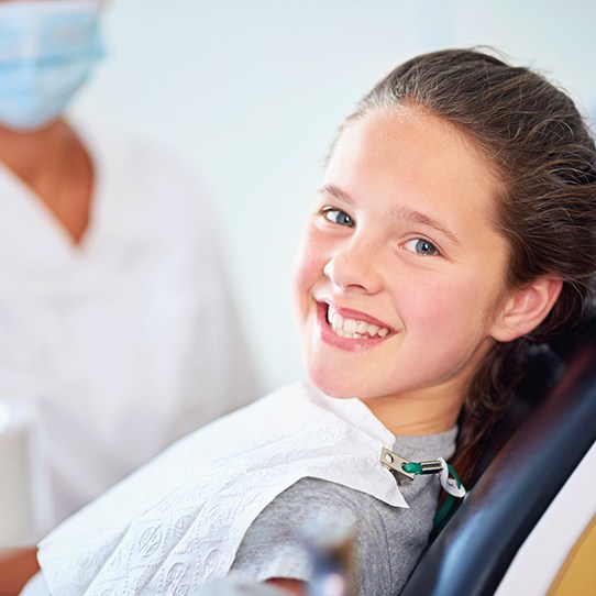 Young girl in dental office smiling after fluoride treatment