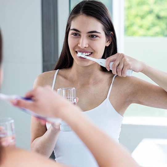 Woman brushing teeth at home