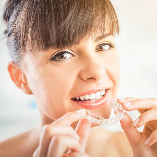 Woman placing Invisalign tray