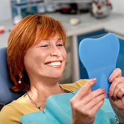 Female patient checking her smile in the mirror