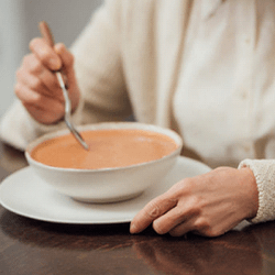 a person eating a bowl of soup