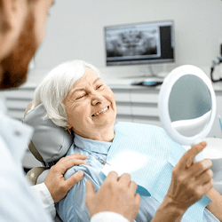 a patient admiring her new dental implants
