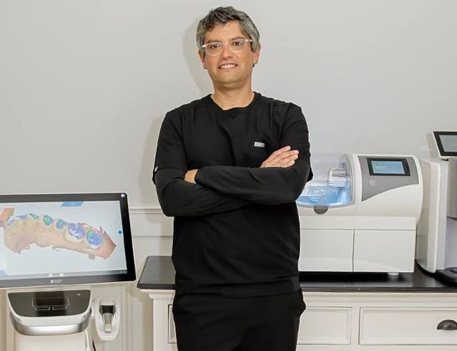 Doctor Graber smiling at dental office reception desk