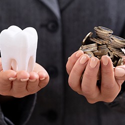 Hands holding tooth and coins