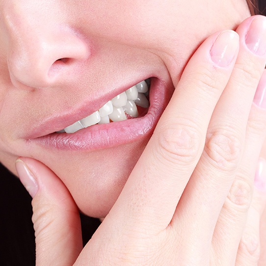 Woman in need of root canal holding jaw