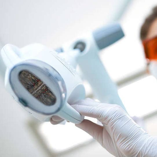 Closeup of dental team member positioning the Zoom teeth whitening light
