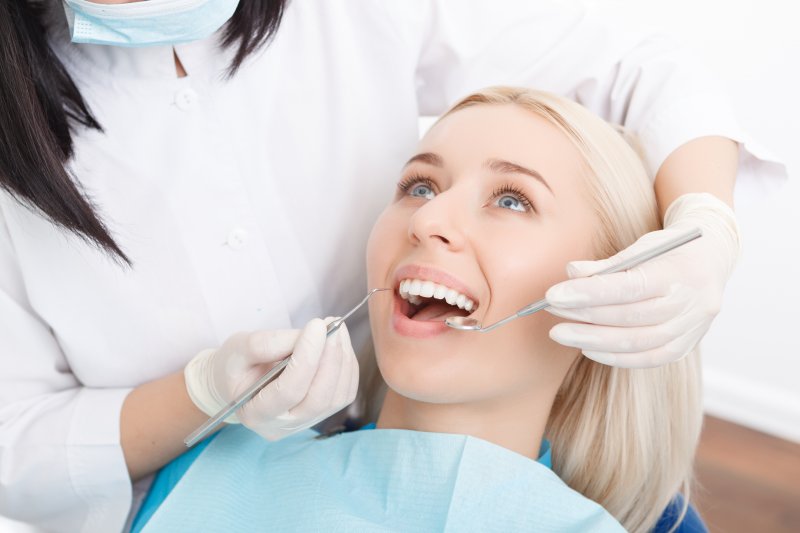 A young woman having her teeth checked during a regular dental exam