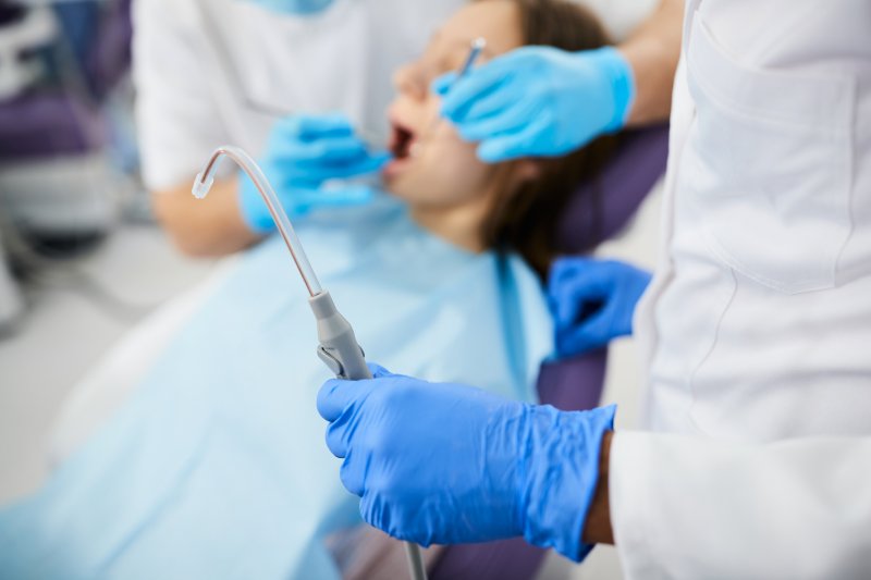 dentist holding dental suction tool
